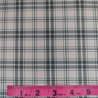 Off-white background with green plaid pattern woven into fabric. Yarn dyed silk. Photographed with a pink ruler to illustrate pattern scale.