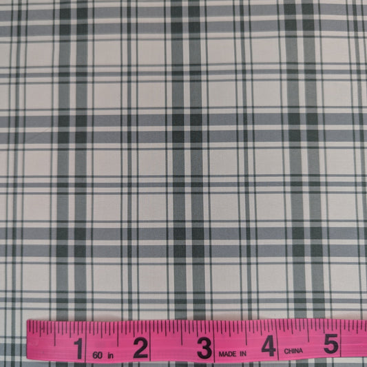 Off-white background with green plaid pattern woven into fabric. Yarn dyed silk. Photographed with a pink ruler to illustrate pattern scale.