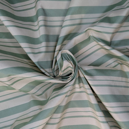 Off-white background with sage green stripe pattern woven into fabric. Yarn dyed silk. Photographed after being swirled to show weight and drape of fabric