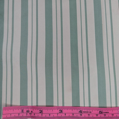 Off-white background with sage green stripes woven into fabric. Yarn dyed silk. Photographed with a pink ruler to illustrate pattern scale.