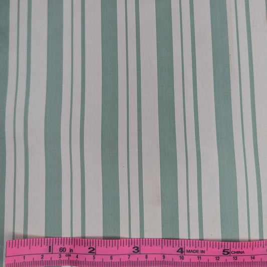 Off-white background with sage green stripes woven into fabric. Yarn dyed silk. Photographed with a pink ruler to illustrate pattern scale.