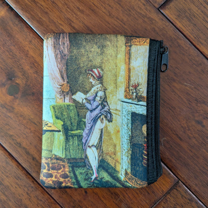 Small zipper pouch printed a woman reading and also lifting her skirt in the back, revealing her bare bum, to warm by the fire in a living room. From the 19th century with a purple dresses and brightly colored room. Virgil's Fine Goods